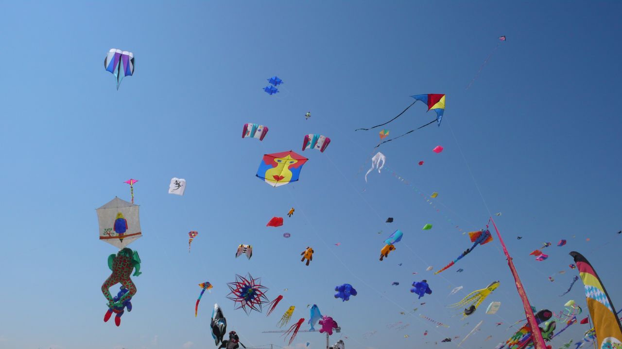 Cielo lleno de cometas de muchos tipos en el festival de Cervia